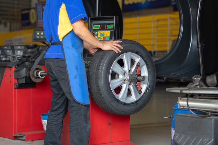 Mecânico com roda de carro
